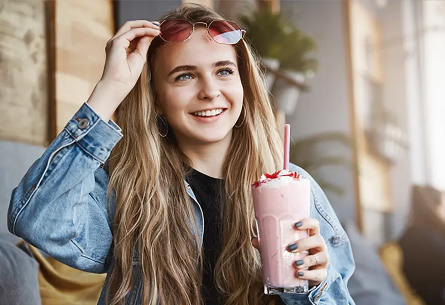 A woman with a shake pushing up her sunglasses