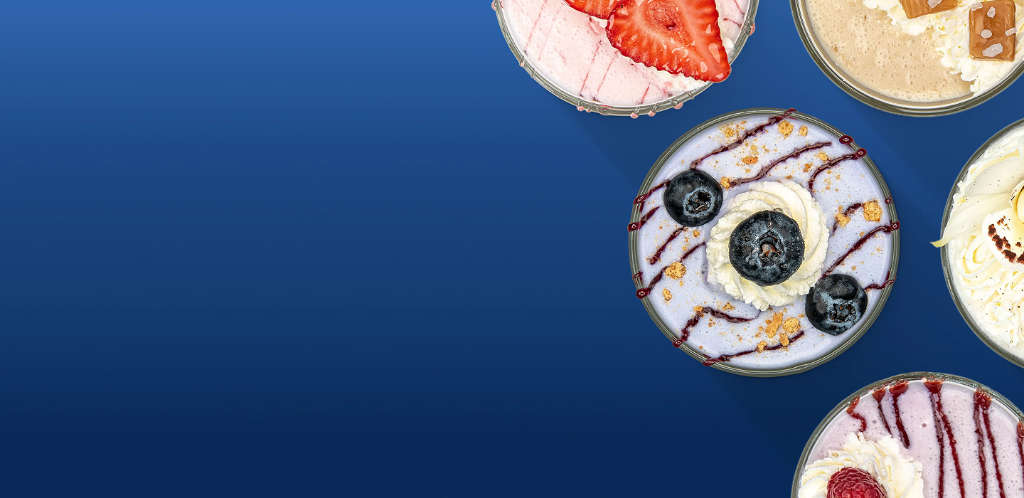 Five circular dessert bowls with various toppings are on a solid blue background.