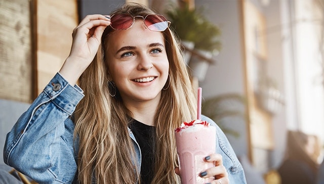 a woman holding a pink Keto Vhow shake