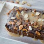 Cinnamon Almond Coffee Cake topped with glaze dripping down onto the white plate