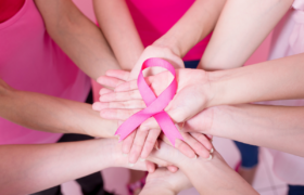 people holding up pink ribbon representing cancer